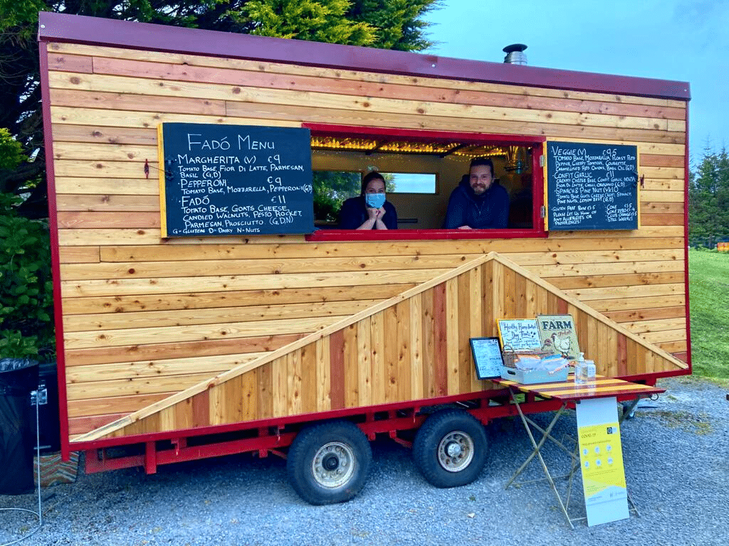 wooden food truck with two people looking out from inside