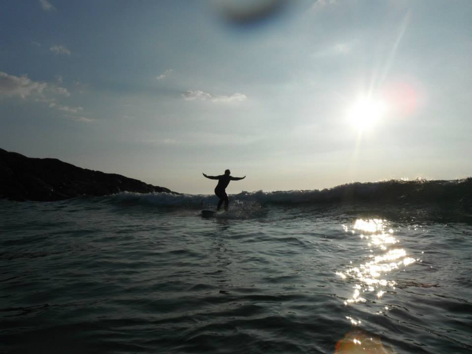 Person standing on surfboard on a sunny day
